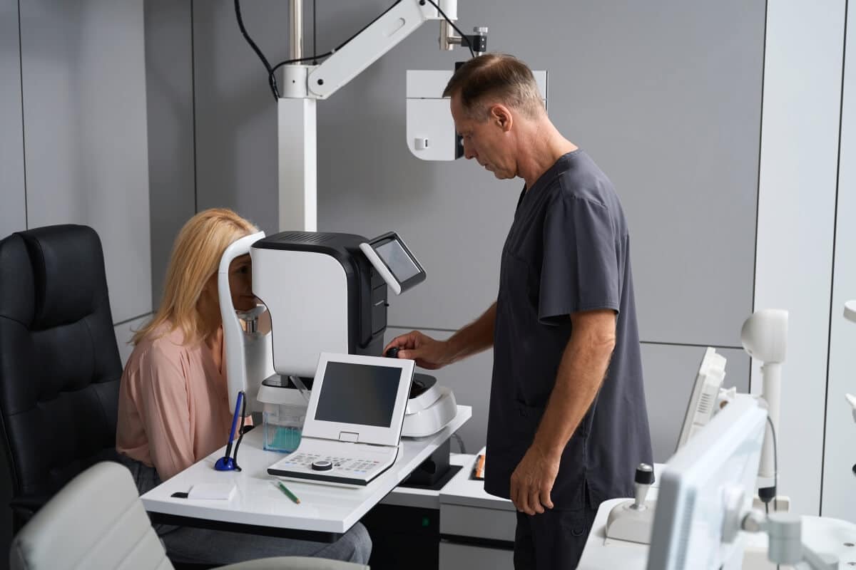 Osoba poddaje się optometrycznemu badaniu wzroku przy pomocy specjalistycznego urządzenia.