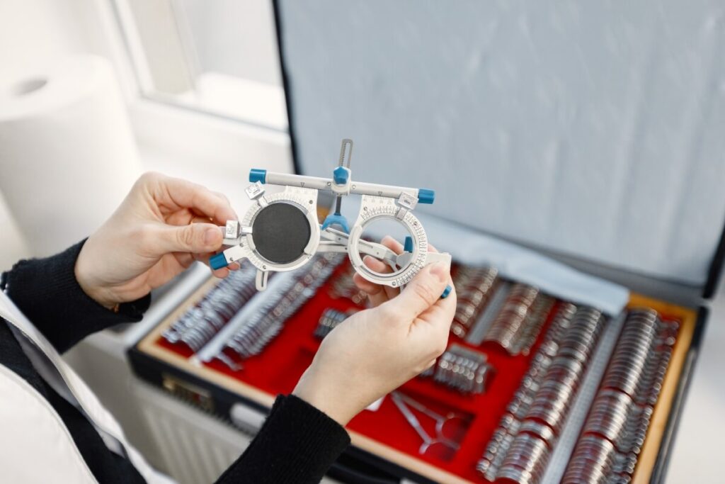 Osoba trzyma urządzenie wykorzystywane do optometrycznego badania wzroku.