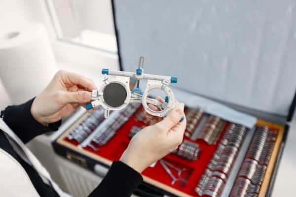 Osoba trzyma urządzenie wykorzystywane do optometrycznego badania wzroku.