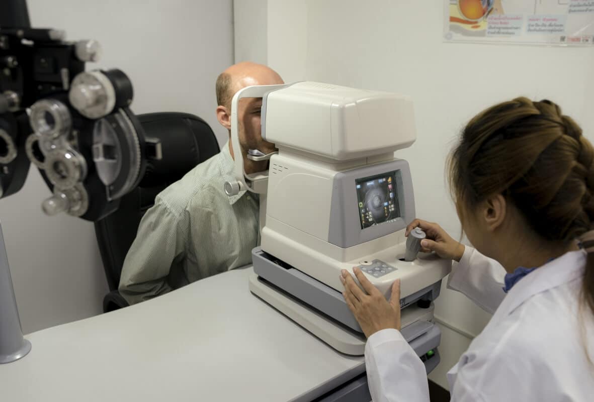 Optometrysta przeprowadza badanie wzroku pacjenta za pomocą specjalistycznego urządzenia.